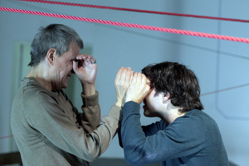 Scene photo of a performance: Two men stand in front of each other on a stage.