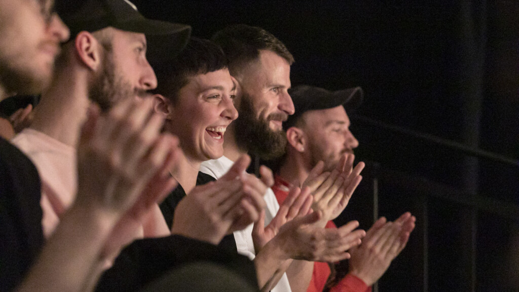 Scene photo of a performance: An audience is clapping.