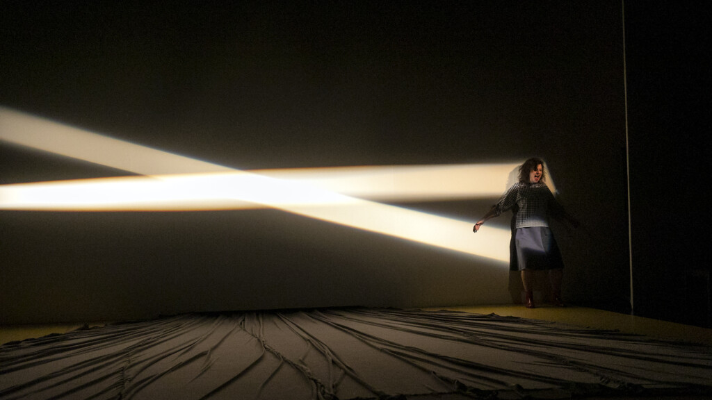 Scene photo of a performance: A screaming woman on a stage.