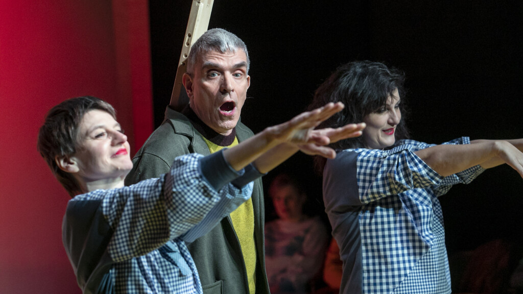 Scene photo of a performance: 3 people on a stage.