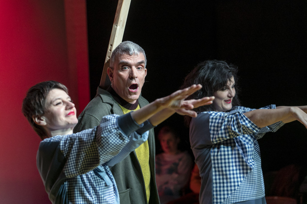 Szenenfoto aus einer Auffuehrung: Zwei Frauen und ein Mann auf einer Theaterbuehne.