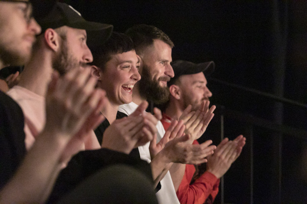 Scene photo of a performance: An audience is clapping.