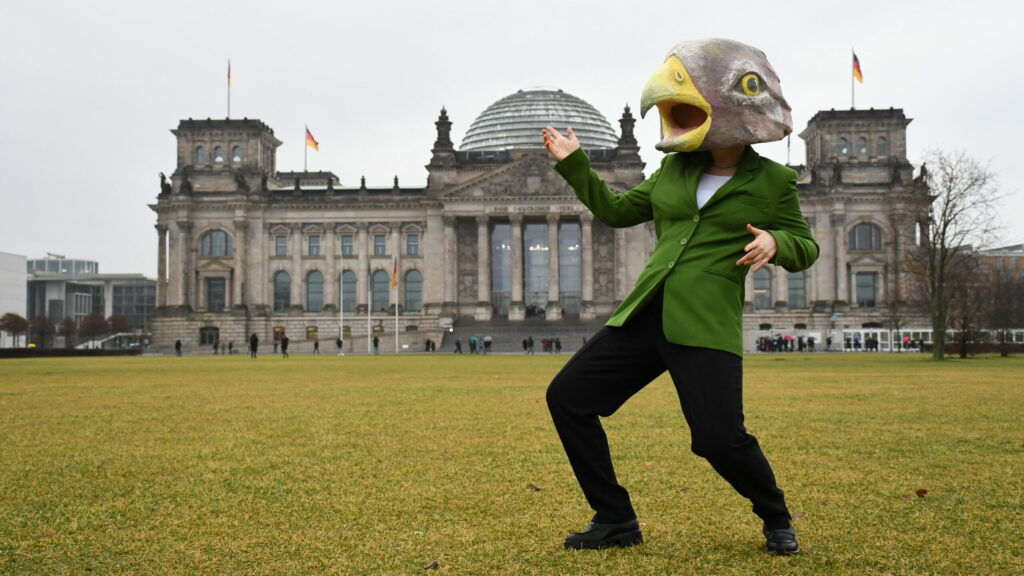 Person mit Adlermaske vor dem Bundestag