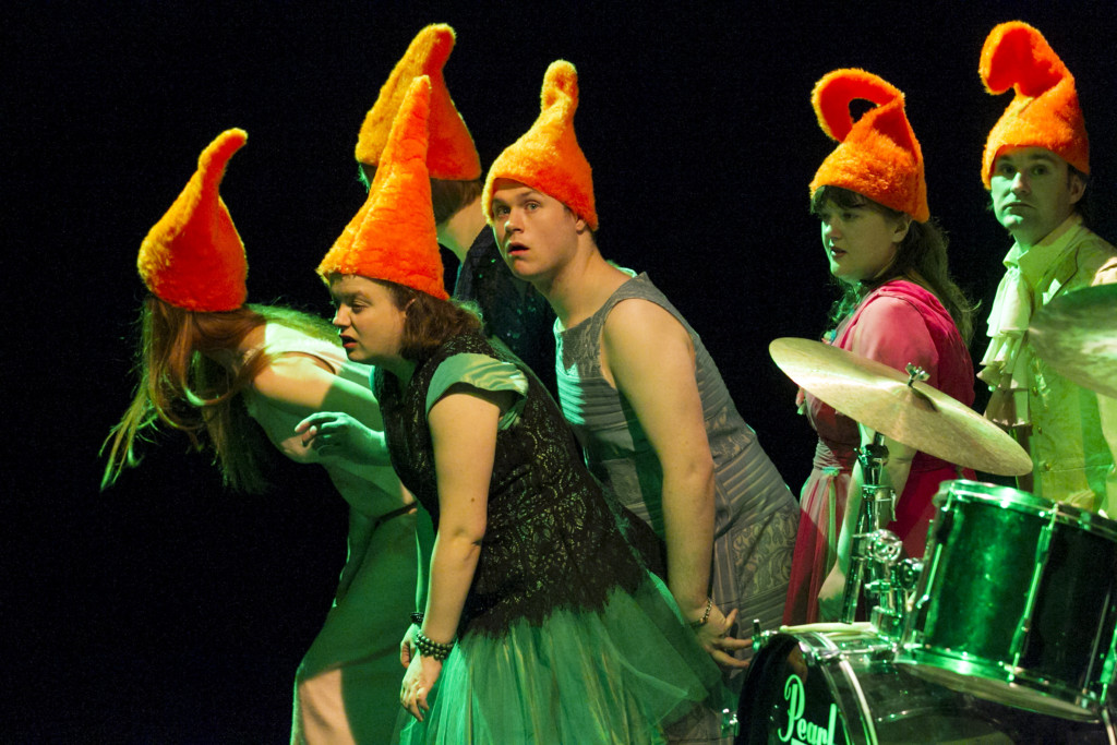 Scene photo of a performance: A couple of people with dwarf hats on a stage.